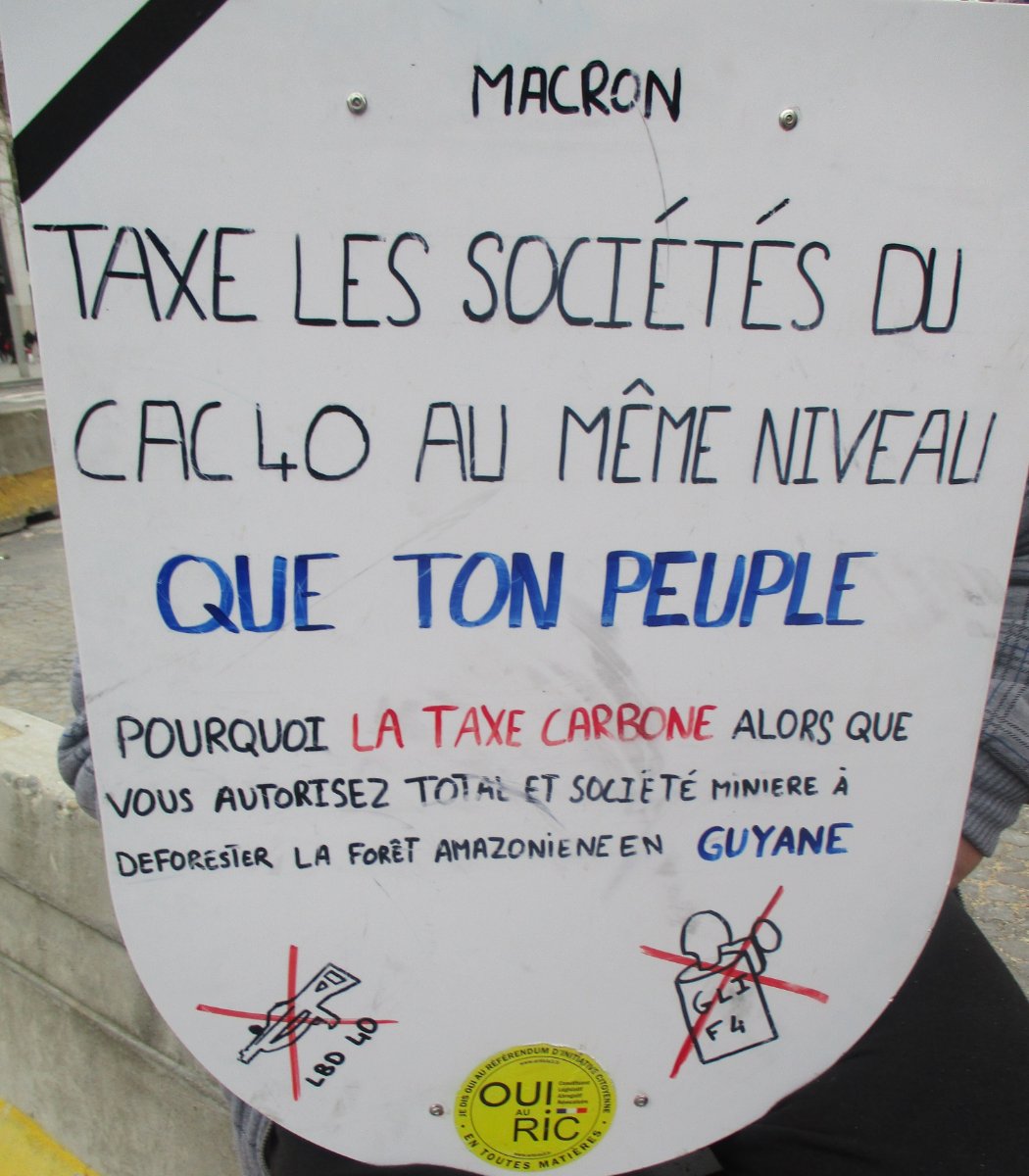 Pancarte « MACRON TAXE LES SOCIÉTÉS DU CAC 40 AU MÊME NIVEAU QUE TON PEUPLE POURQUOI LA TAXE CARBONE ALORS QUE VOUS AUTORISEZ TOTA… », Paris (75), 9 mars 2019