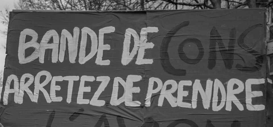 Pancarte « BANDE DE CONS ARRETEZ DE PRENDRE L'AVION », Paris (75), 8 décembre 2018