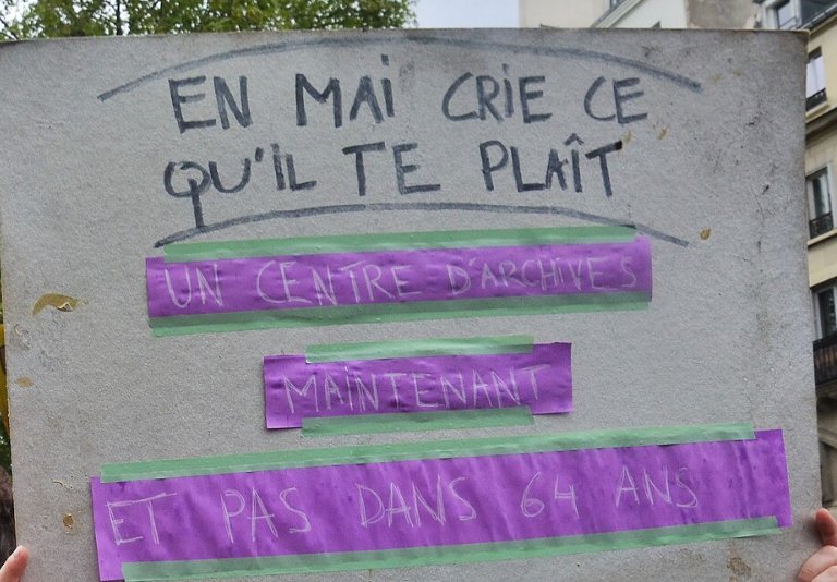 Pancarte « EN MAI CRIE CE QU'IL TE PLAÎT UN CENTRE D'ARCHIVES MAINTENANT ET PAS DANS 64 ANS », Paris (75), 1 mai 2023
