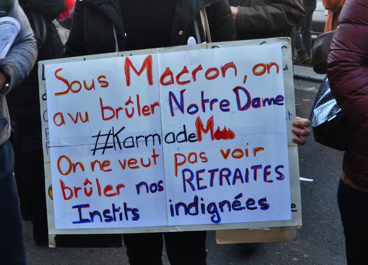 Pancarte « Sous Macron, on a vu brûler Notre Dame #KarmadeMacron On ne veut pas voir brûler nos RETRAITES Instits indigné.es », Paris (75), 16 janvier 2020