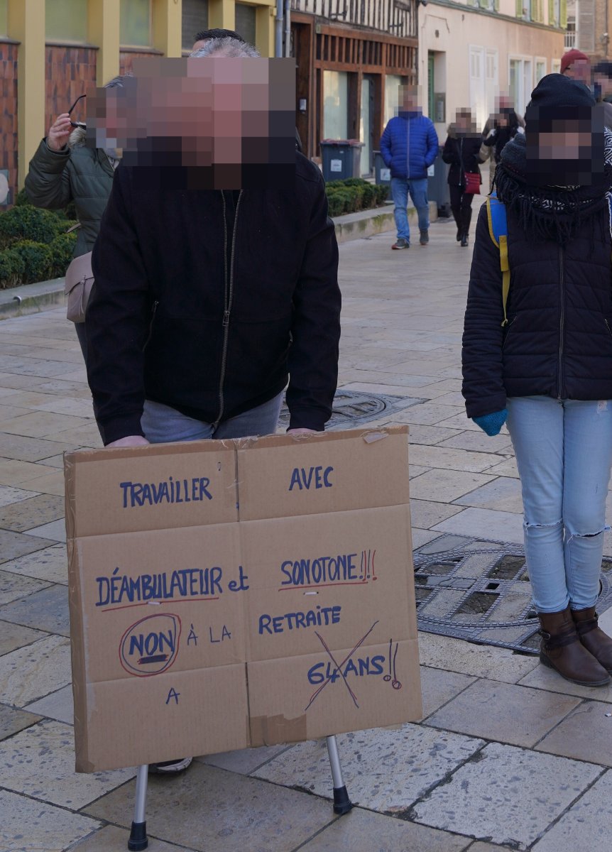 Pancarte « TRAVAILLER AVEC DÉAMBULATEUR et SONOTONE!!! NON À LA RETRAITE A 64 ANS!! », Troyes (10), 11 février 2023