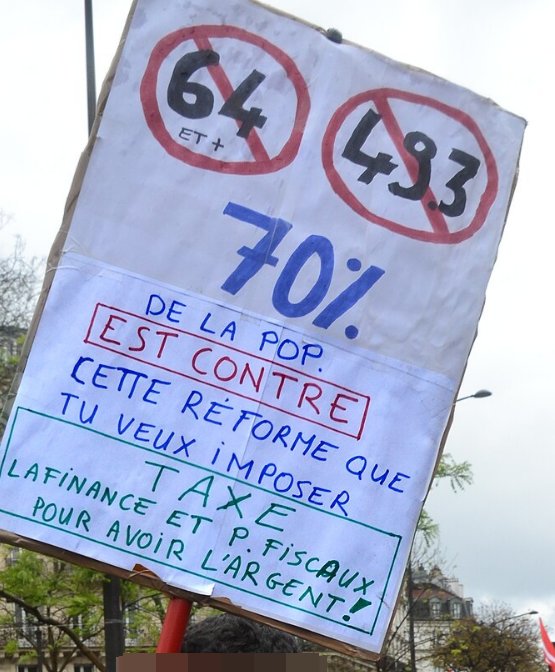 Pancarte « 64 ET + 49.3 70% DE LA POP. EST CONTRE CETTE RÉFORME QUE TU VEUX IMPOSER TAXE LA FINANCE ET P. FISCAUX POUR AVOIR L'ARG… », Paris (75), 1 mai 2023