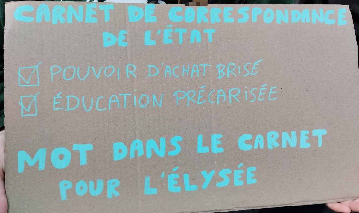 Pancarte « CARNET DE CORRESPONDANCE DE L'ÉTAT Pouvoir d'achat brisé Éducation précarisée MOT DANS LE CARNET DE L'ÉLYSÉE », Paris (75), 17 octobre 2026