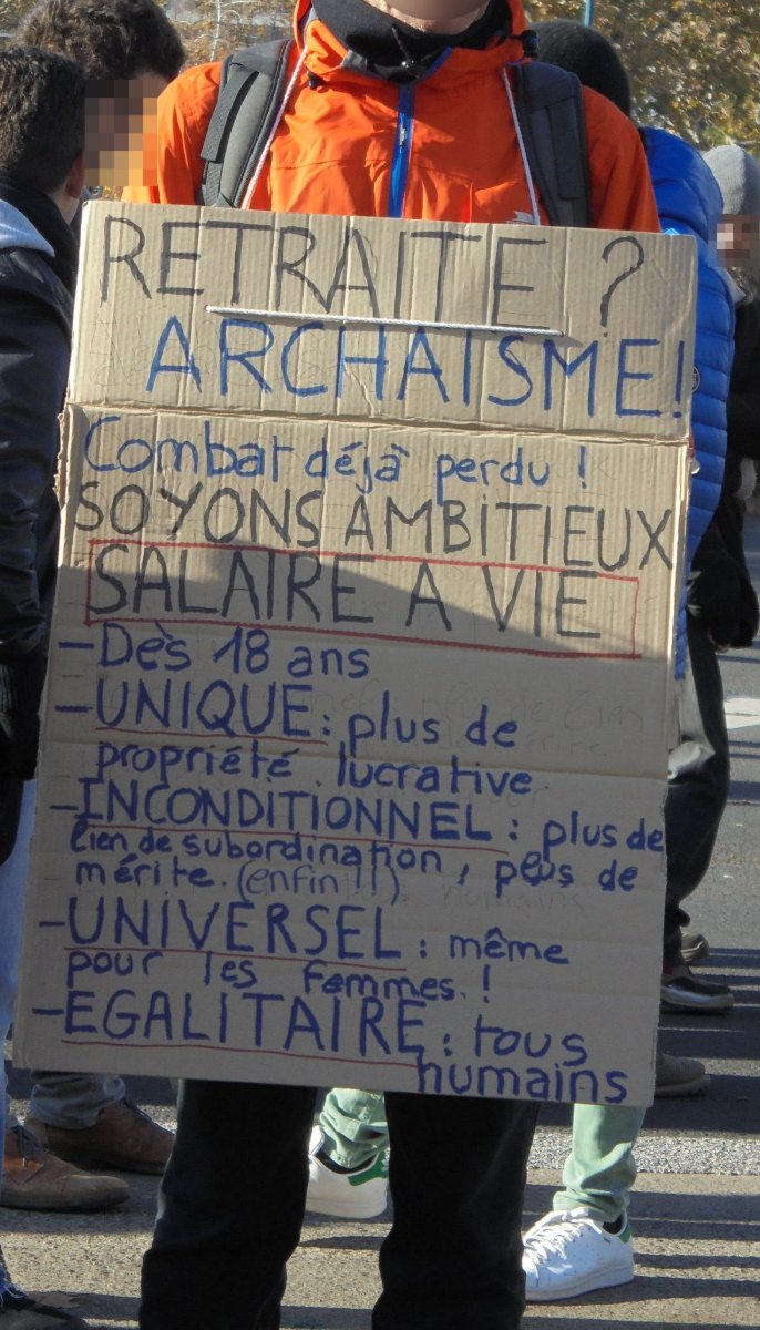 Pancarte « RETRAITE ? ARCHAISME! Combat déjà perdu ! SOYONS AMBITIEUX SALAIRE A VIE - Dès 18 ans - UNIQUE: plus de propriété lucra… », Clermont-Ferrand (63), 5 décembre 2019